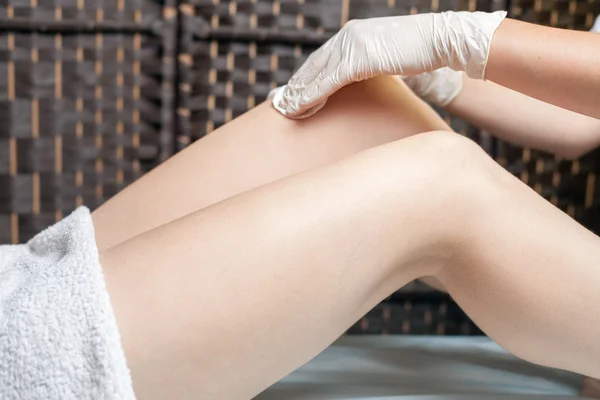 Sugaring epilation skin care with liquid sugar at legs