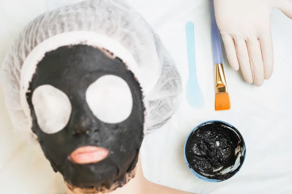 Rejuvenation and skincare in spa salon with mud face mask