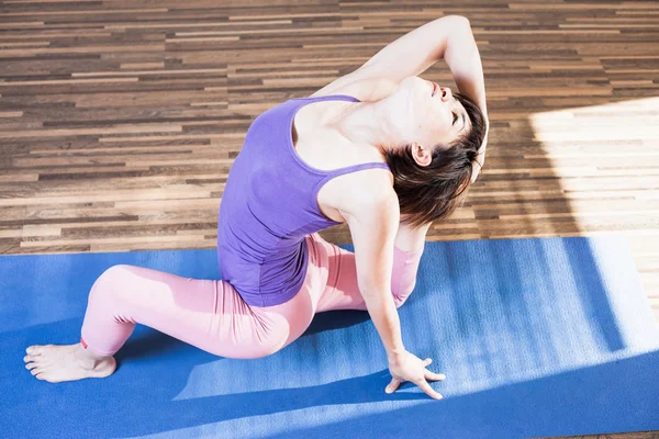 Inspired asian woman doing exercise of yoga indoor