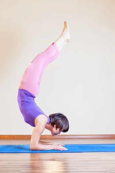 Asian woman doing exercise of yoga at mat