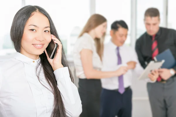 Successful asian business woman using mobile phone