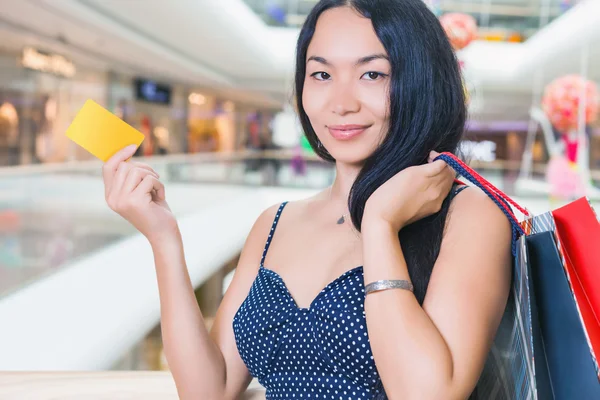 Close-up of woman\'s hand holding credit card and bags