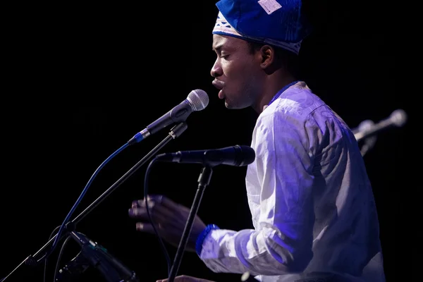 African man singing and playing ethnic drums