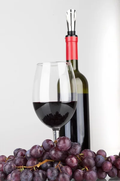 Red wine in glass with grapes isolated on white background