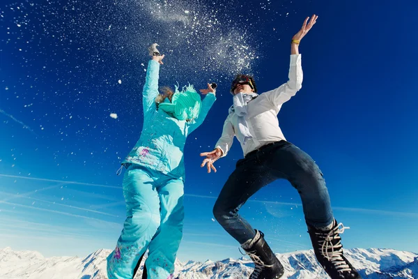 Woman and man in ski suit jump