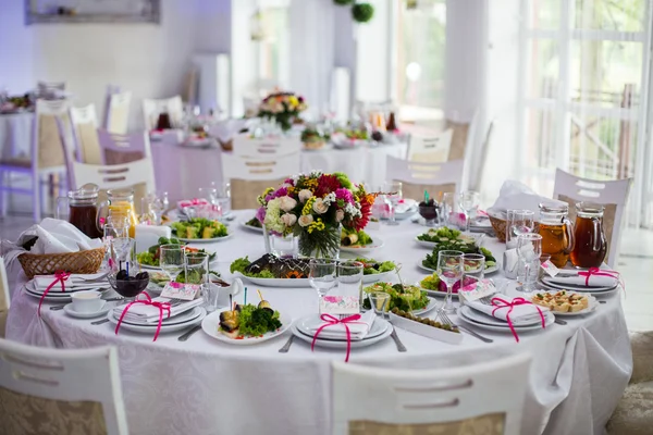 White tables with flowers and food