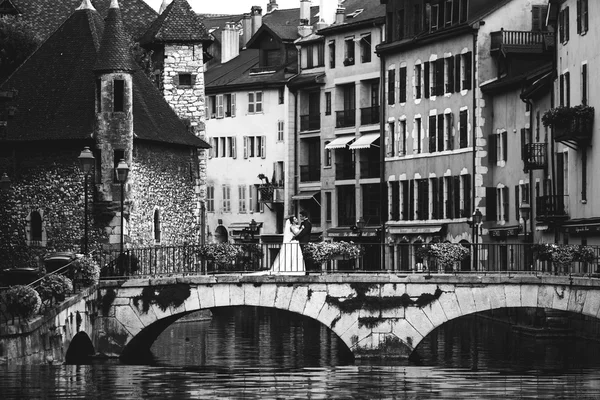 Bride and groom hugging on old romantic bridge