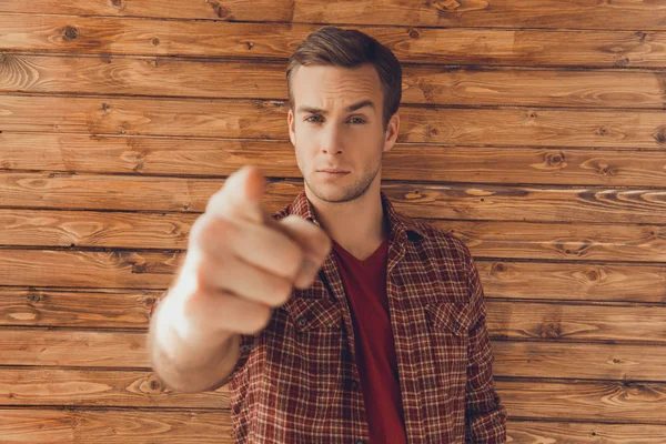 Portrait of handsome man pointing on camera, focus on hand