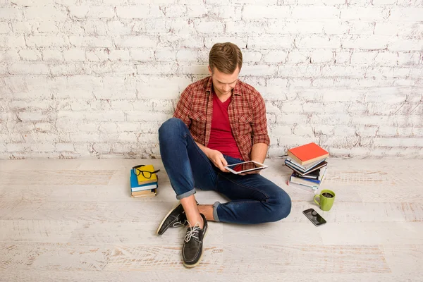 Portrait of student with books and tablet preparing for exams
