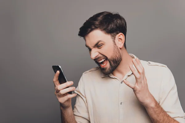 Portrait of overworked sad businessman holding phone and yelling