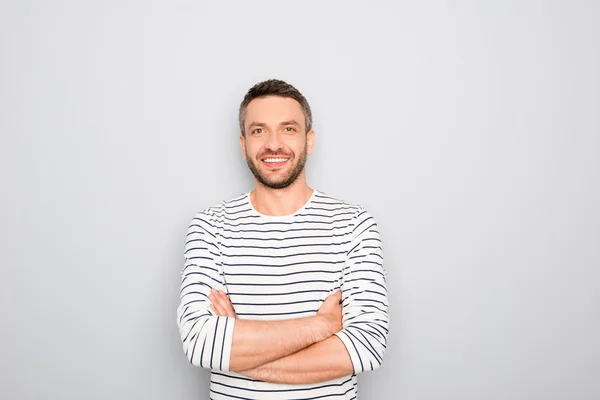 Cheerful happy guy with crossed hands on white background