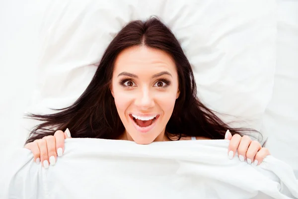 Top view portrait of pleasantly surprised woman after sleep