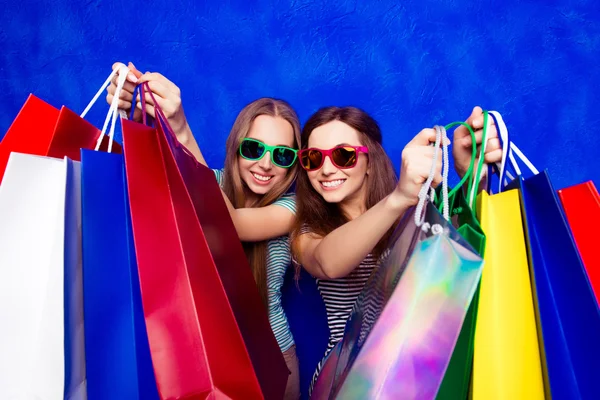 Young pretty women in glasses with shopping packages in the shop