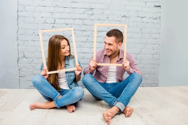 Portrait of happy smiling man and woman posing inside frames