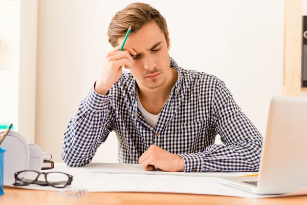 Serious tired architect thinking about way to end plan
