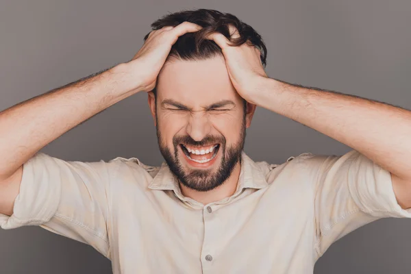 Frustrated angry man with big problems yelling and touching head