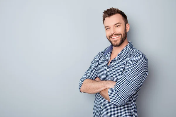 Portrait of toothy handsome bearded man with crossed hands