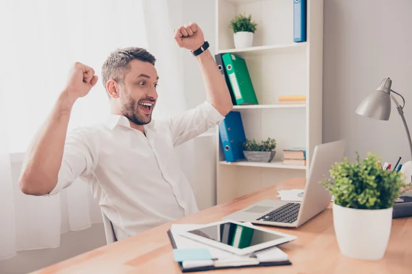 Happy man completed task and triumphing with raised hands