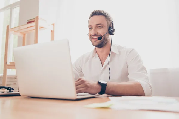 Portrait of handsome smiling operator with head-phones and lapto