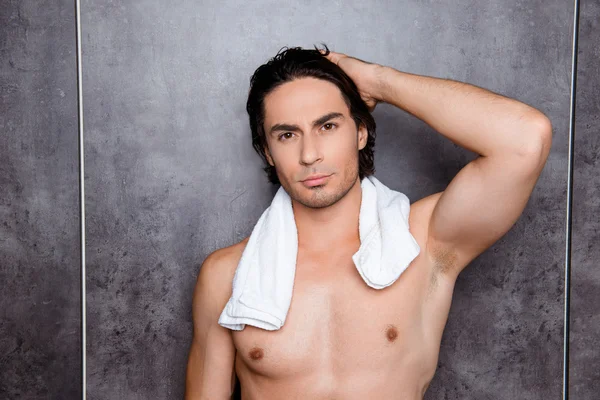 Portrait  of sexy young man with  white towel touching his black
