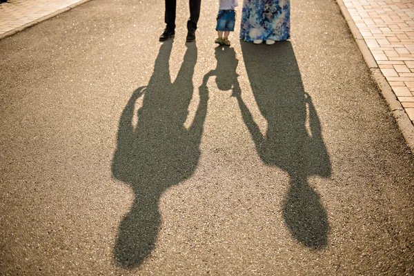 Family walking with baby. image of family\'s shadows