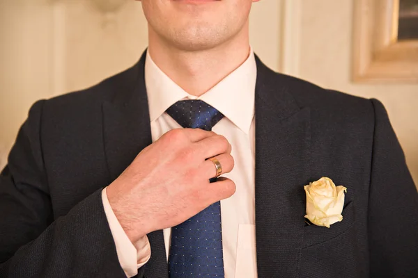 Cropped image of man in suit. A man wearing a jacket with a bout