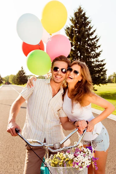 Happy young couple in love with balloons and bicycles