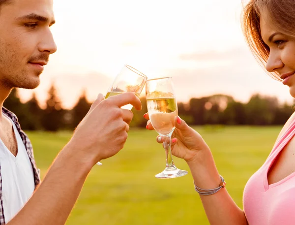 Young couple drinking champagne at sunset