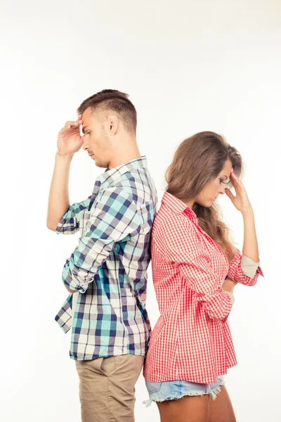 Young couple standing back to back ignoring each other