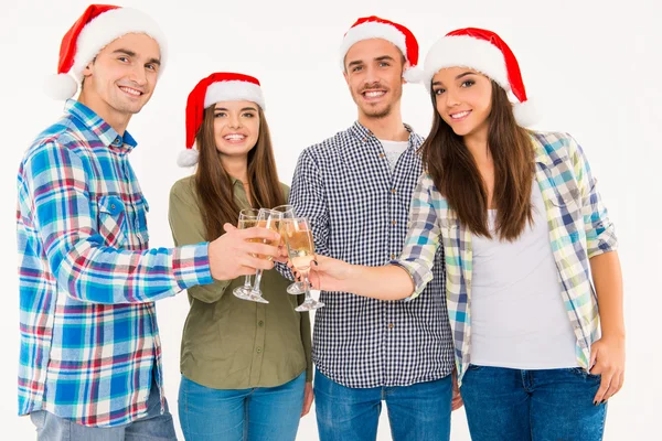 Group of funny young people in santa hats celebrating xmas with