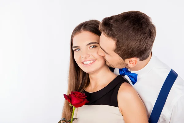 Cute young man kissing his girlfriend with a rose