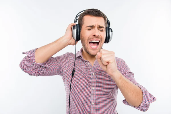 Smilling man with headphones singing in hand like in microphone