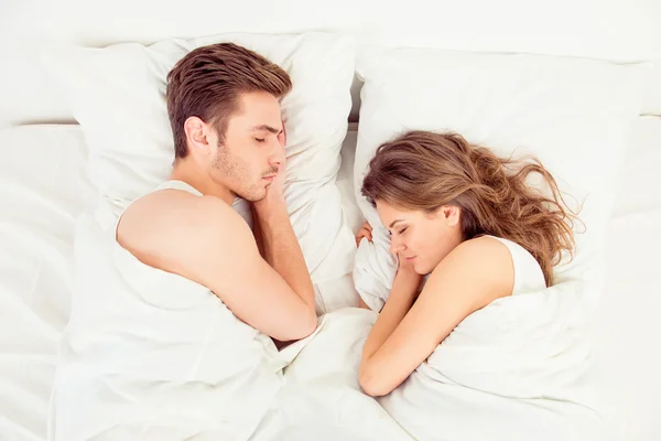 Beautiful couple sleeping together in bedroom