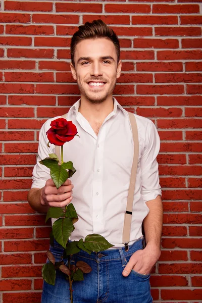 Close up photo of cheerful young  man with rose