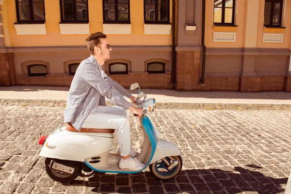 Side view photo of young man riding a motor bike