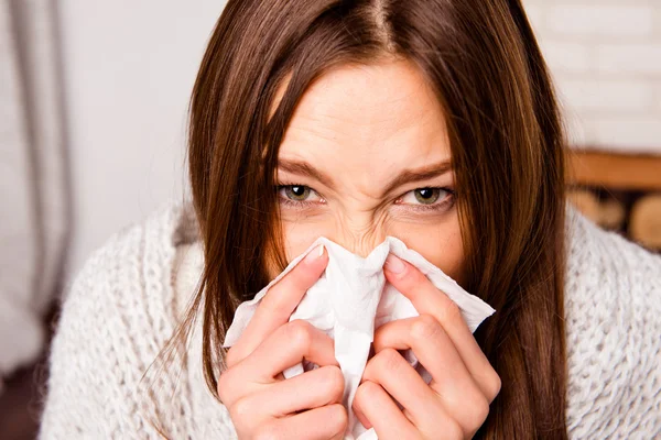 Close up portrait of sick woman  with fever sneezing in tissue