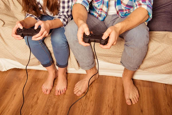 Couple in love at home playing video games with joysticks