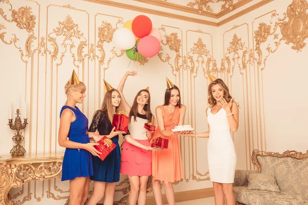 Cheerful pretty girls holding balloons and presents showing birt