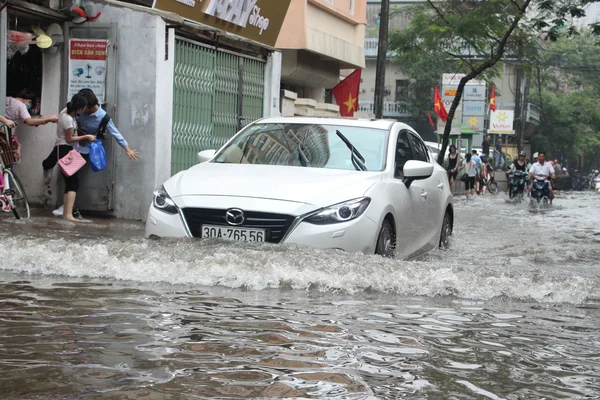 Hanoi, Vietnam - May 25, 2016: A car is driving in the flood in the center of Hanoi city in Vietnam