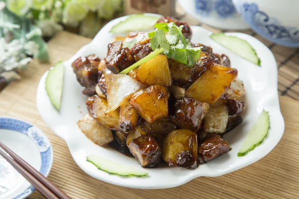 Vietnamese braised cube of pork with pineapple on white plate on