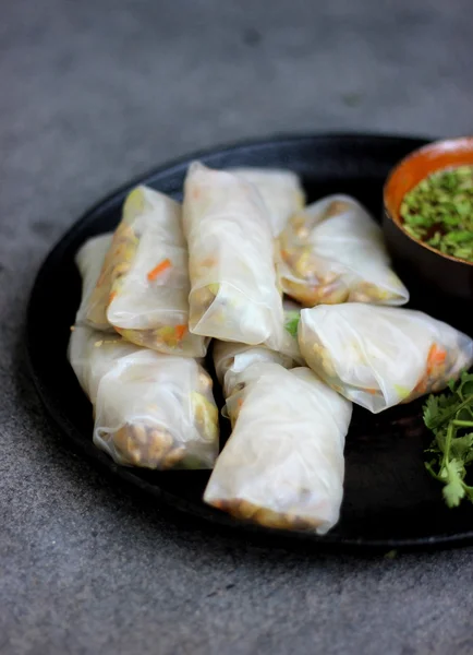 Chinese chicken spring rolls recipe with herbs on black plate