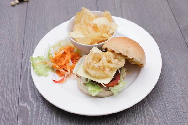 Fried tempura hamburger with fried potatoes and salad on white p