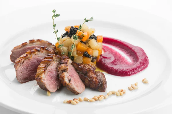 Breast of duck magret with fruit gratin and apple sauce on white
