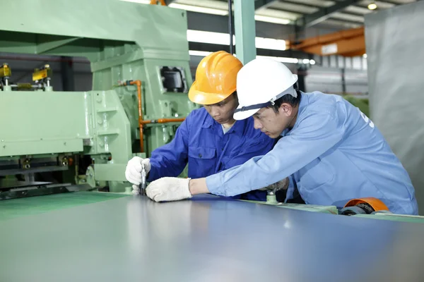 Two workers are working in a mechanical workshop