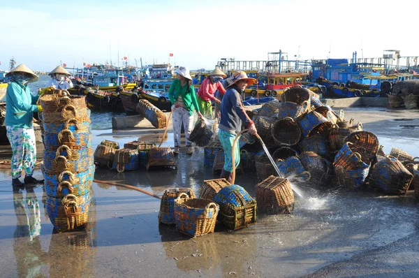 Lagi, Vietnam - February 26, 2012: Local women are cleaning their baskets which were used for transporting fishes from the boat to the truck