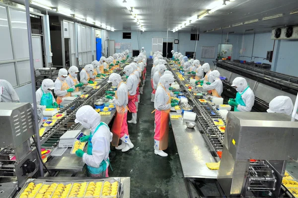 Ho Chi Minh city, Vietnam - October 3, 2011: Workers are working hard on a production line in a seafood factory in Ho Chi Minh city, Vietnam