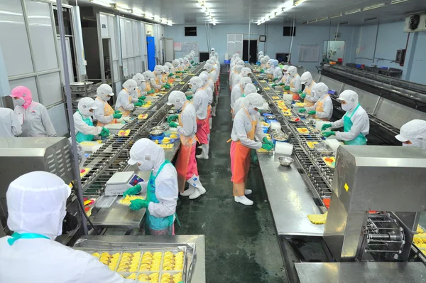 Ho Chi Minh city, Vietnam - October 3, 2011: Workers are working hard on a production line in a seafood factory in Ho Chi Minh city, Vietnam