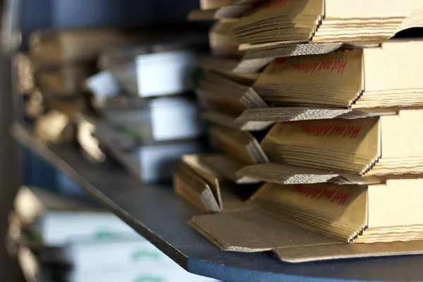 Stack of pizza boxes on shelf