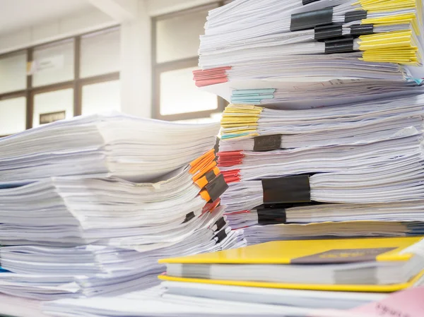 Pile of unfinished documents on office desk
