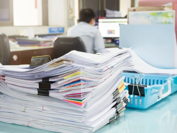 Pile of unfinished paperwork on office desk